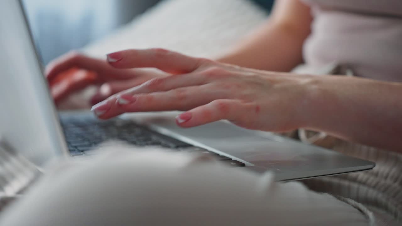 Nærbillede af kvindes hænder, der taster på et tastatur på en bærbar computer