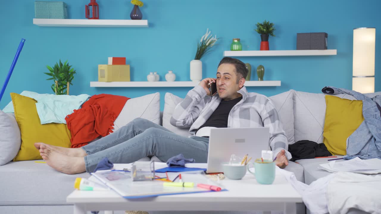 hombre perezoso riéndose del teléfono en la mano y no haciendo su trabajo.