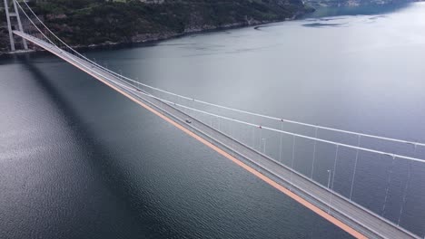 looking down at norways largest suspension bridge in hardanger - high altitude aerial over bridge with traffic passing and fjord below