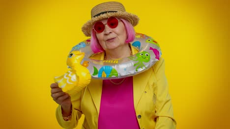 senior grandmother traveler tourist with swimming ring ready for vacation, journey trip to seaside