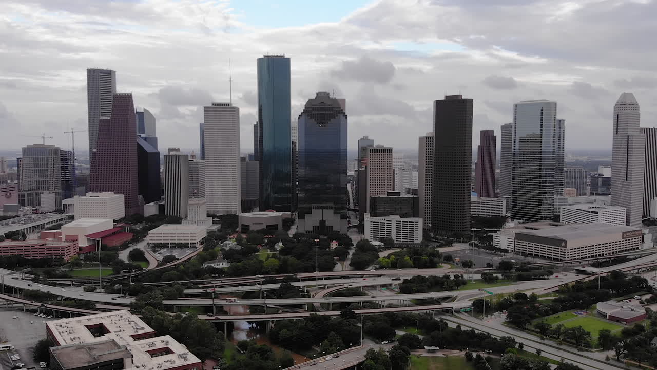 Toma de dron inversa del horizonte de Houston con coches circulando en un día nublado