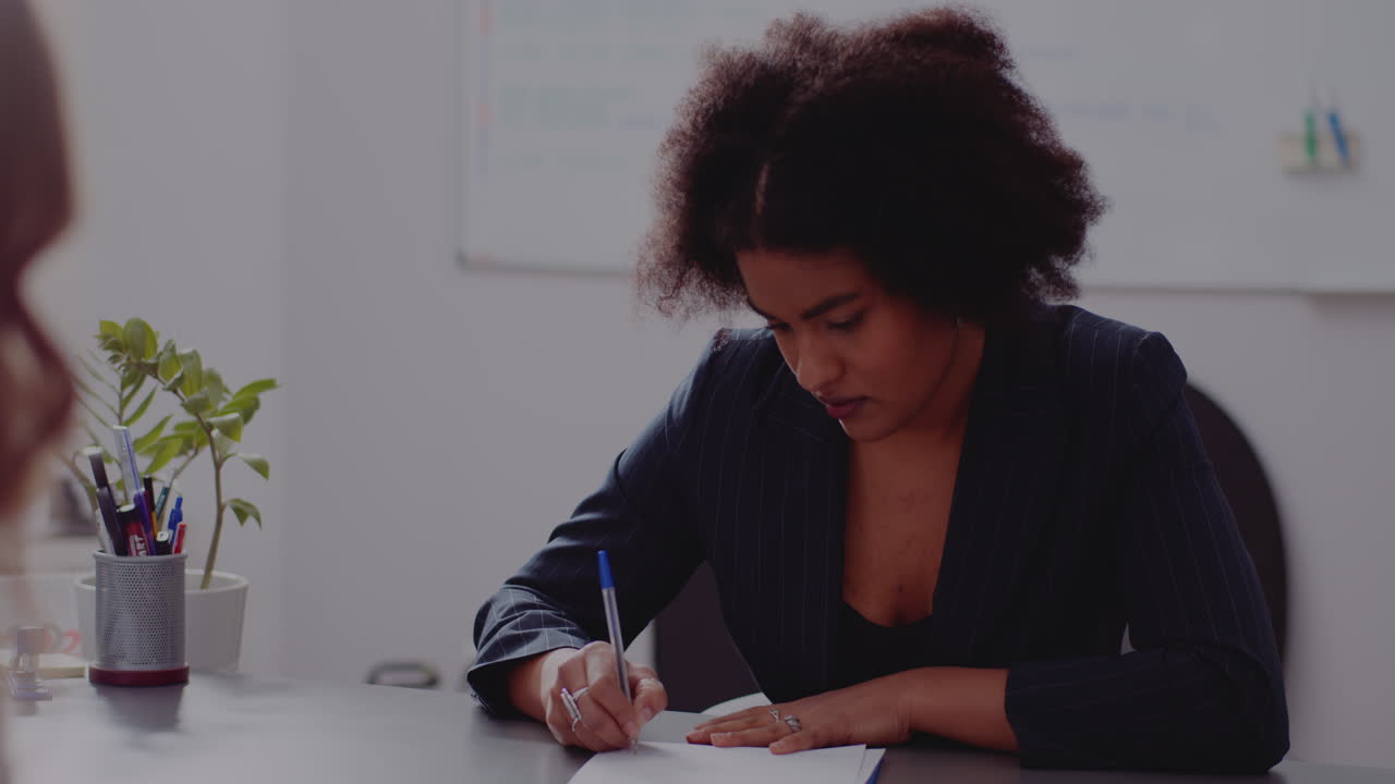 Businesswoman writing at desk in office