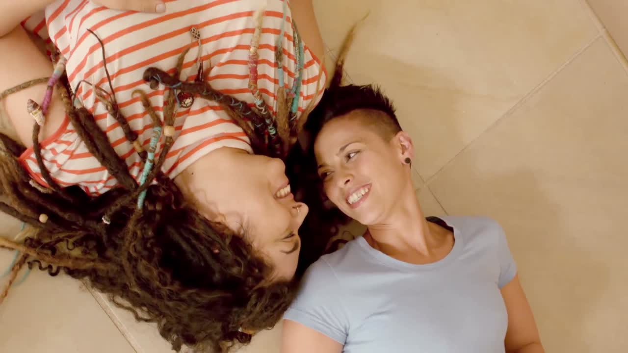 Coppia lesbica felice sdraiata sul pavimento