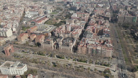Forwards-fly-above-city.-Aerial-footage-of-Promenade-Passeig-de-Lluis-Companys-with-Arc-de-Triomf-and-historic-court-building.-Barcelona,-Spain