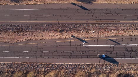 Vista-Aérea-De-Pájaro-De-La-Antigua-Autopista-Americana,-Coches-Moviéndose-Sobre-Asfalto-Agrietado,-Disparo-De-Drones-En-ángulo-Alto