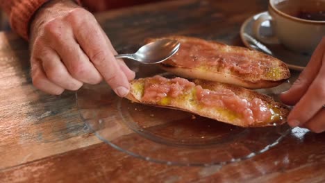 crop man spreading mashed tomatoes on toasts