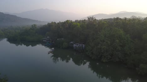 vista panorámica en la playa de palolem, canacona en el sur de goa, india compuesta de árboles verdes y agua tranquila con montaña en el fondo - toma aérea