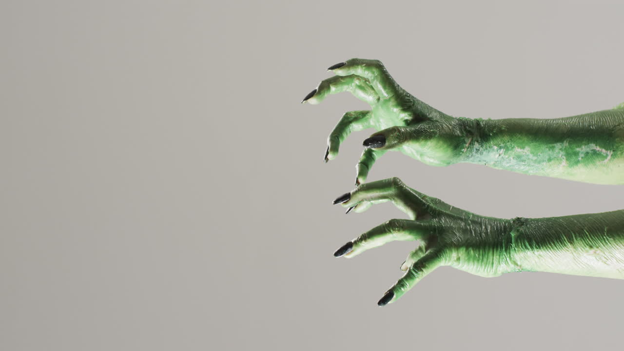 video de las manos del monstruo verde de halloween con espacio de copia en fondo gris