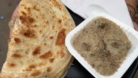 lachha paratha served with mutton rezala at a roadside stall in india