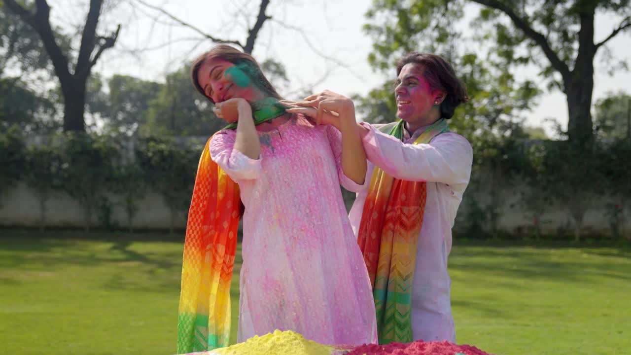 Uomo indiano che mette i colori dell'Holi sul viso di sua moglie