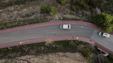 get a bird's eye view of the road at malaga with drone footage capturing a parked white four-wheeler and another vehicle passing by