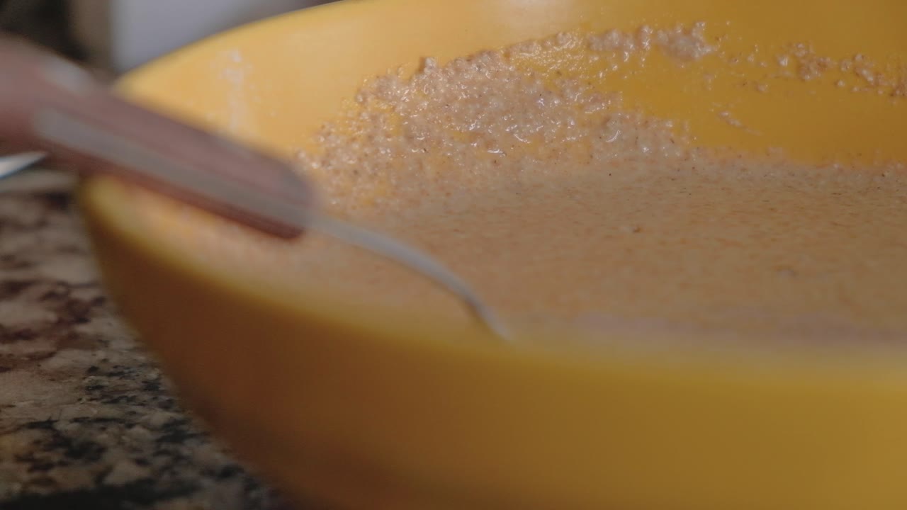 primer plano de manos de mujer mezclando la masa fervientemente con un tenedor para combinarla