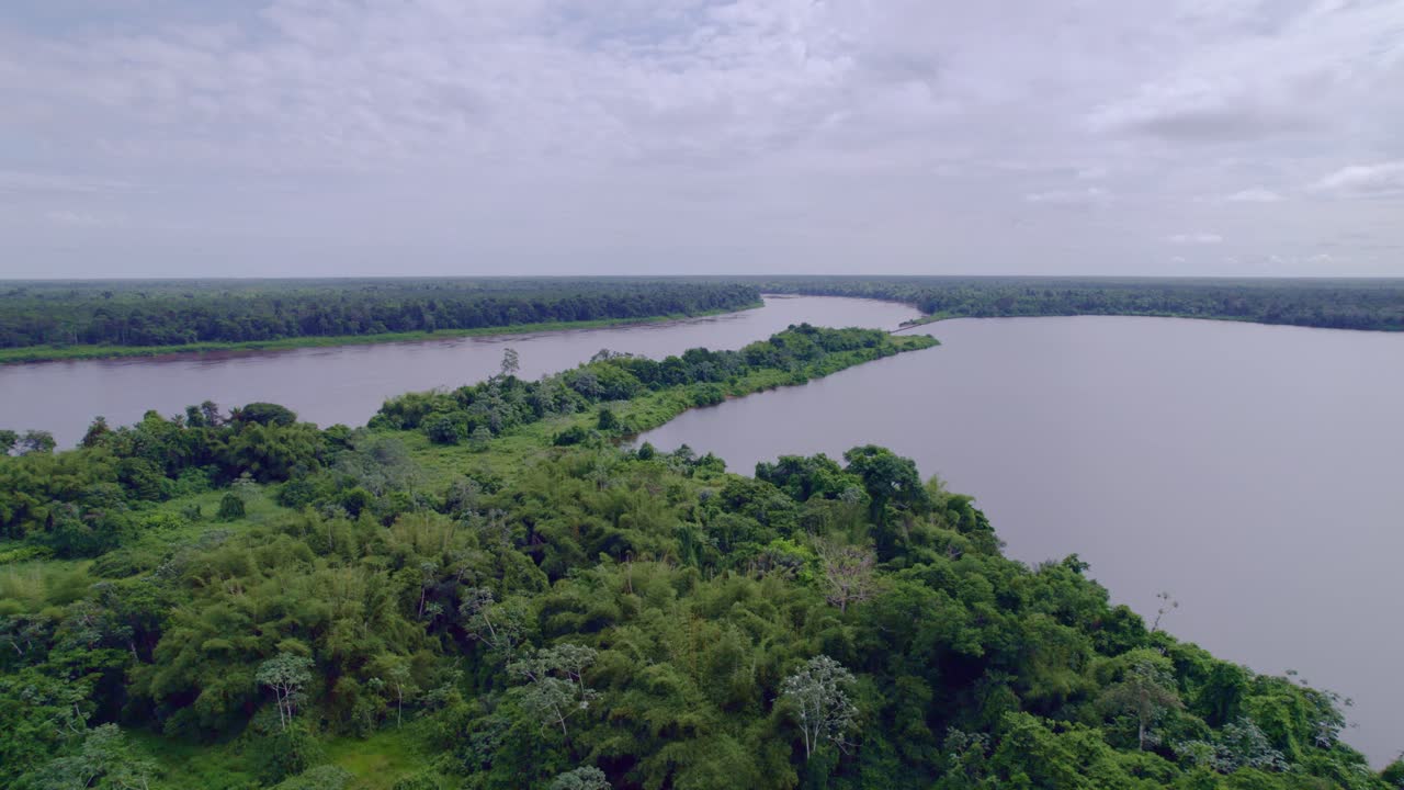 Fly past lake meeting river in the Amazon, South America, low angle