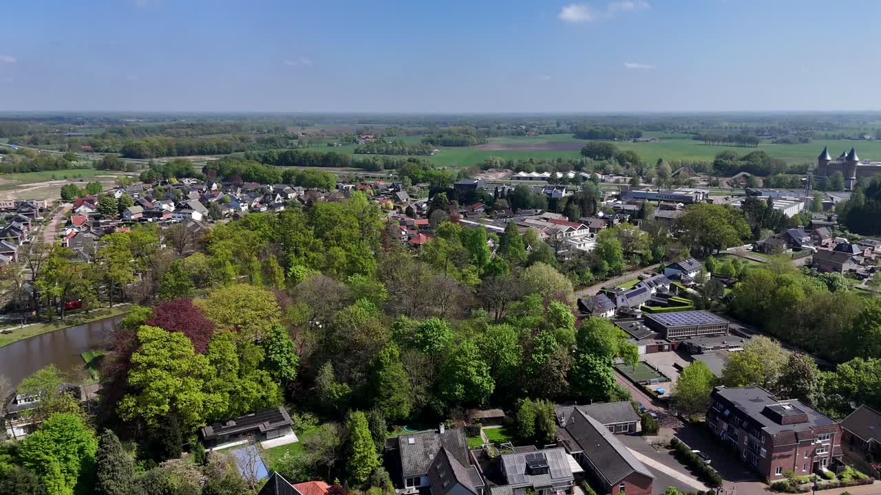 Colored Trees at river of american town. Aerial wide shot. Sunny day with blue sky and agricultural farm fields in distance. Houses and homes in small american town.