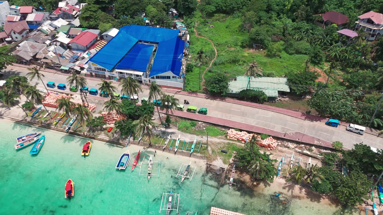 Smooth 4K drone tilt revealing Boracay town, vibrant rooftops, and lush green hills—perfect for tourism, travel, and tropical destination storytelling in the Philippines