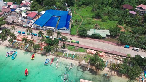 smooth 4k drone tilt revealing boracay town, vibrant rooftops, and lush green hills—perfect for tourism, travel, and tropical destination storytelling in the philippines