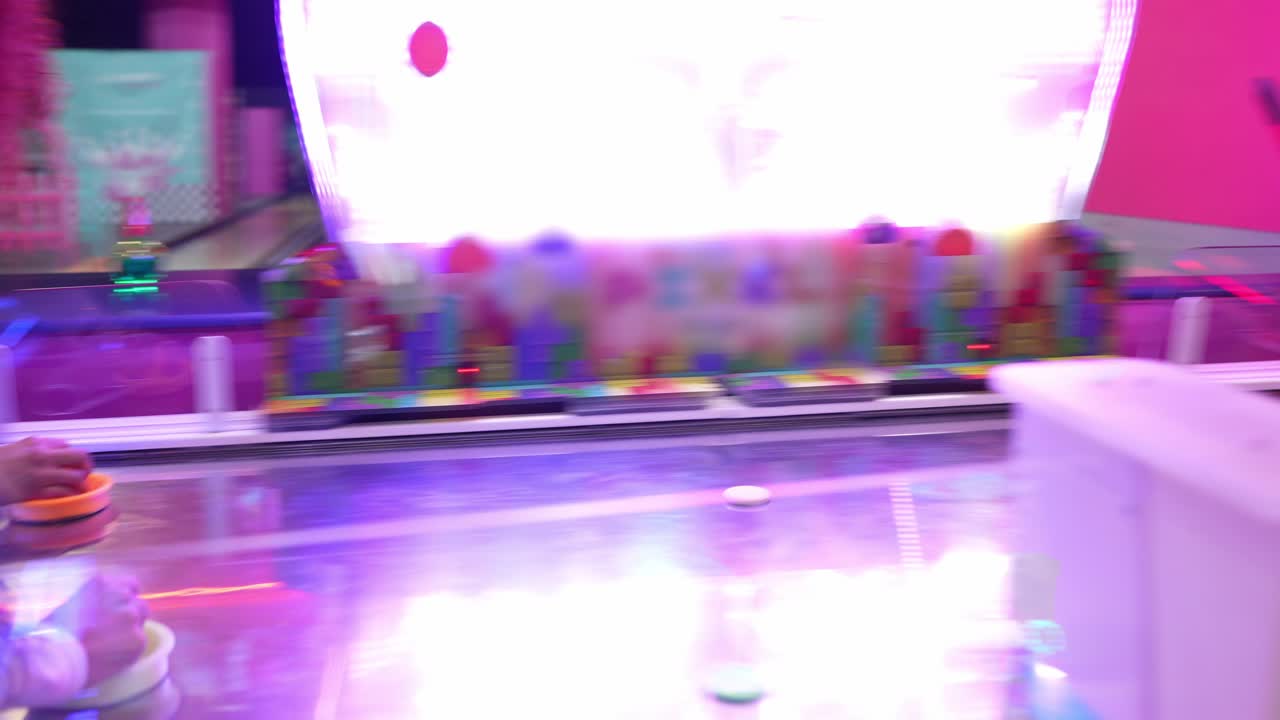 People playing air hockey at an arcade