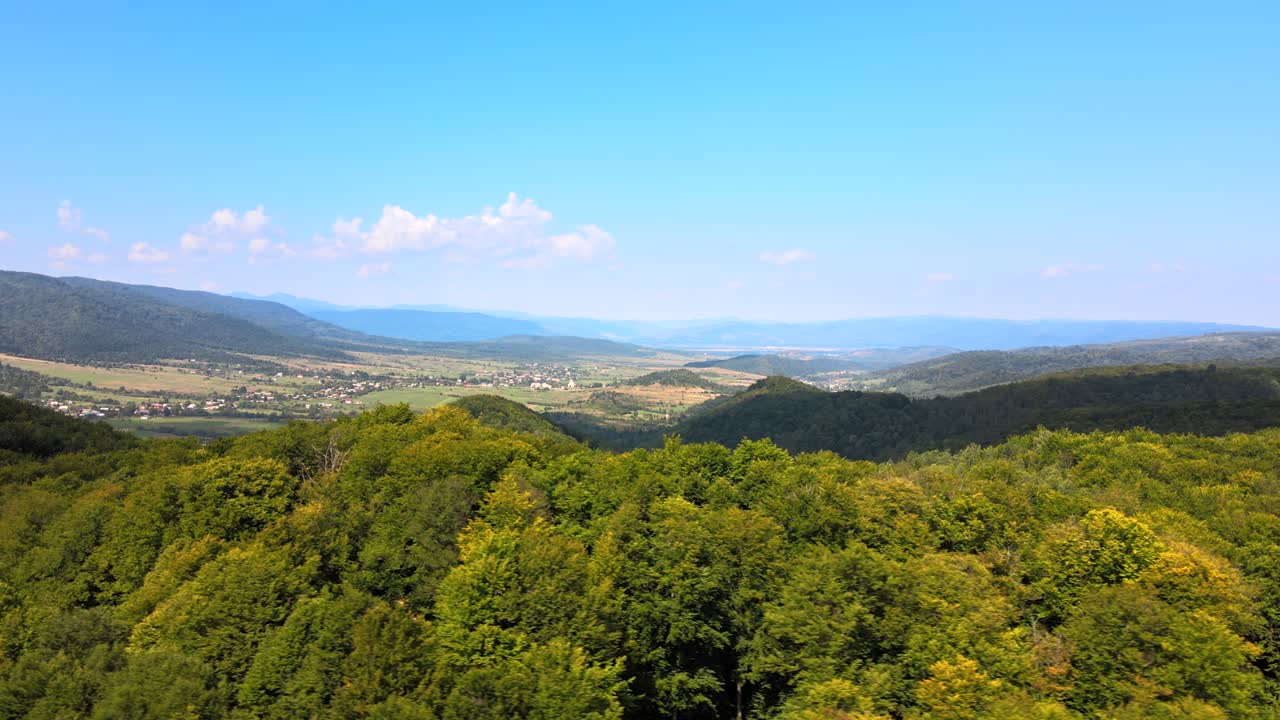 vista aérea de colinas de montaña cubiertas de densos bosques verdes y exuberantes en un brillante día de verano