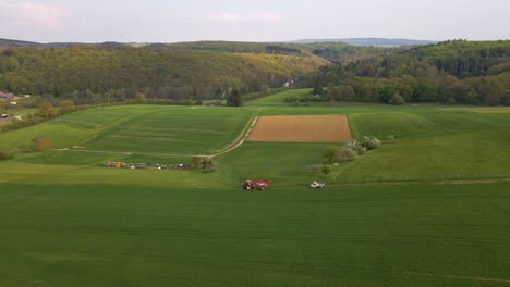 aerial view of a tractor followed by a van going into the meadows to get to work