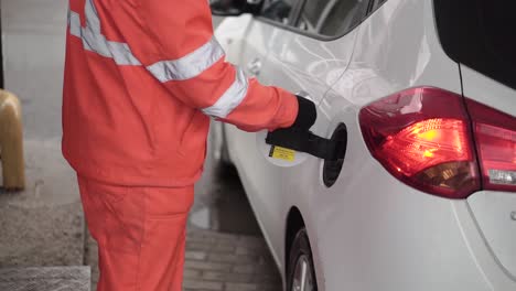 person fueling a car at a gas station