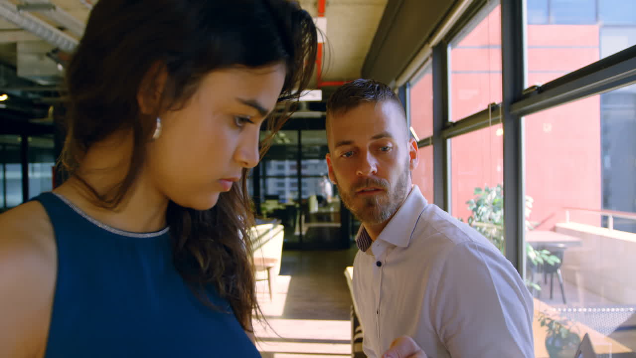 ejecutivos discutiendo sobre la computadora portátil en la oficina 4k