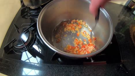 mujer en la cocina cocinando salsa en una olla