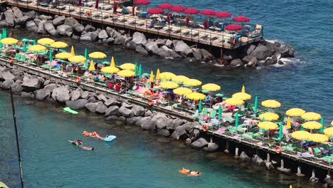 people relaxing under umbrellas by the sea