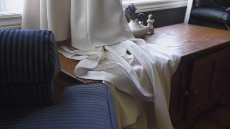 beautiful white wedding dress draping over a wooden chest