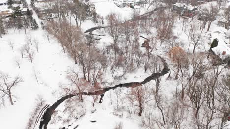 Aerial-reveal-snow-covered-houses-in-small-town-suburban-neighborhood-during-winter