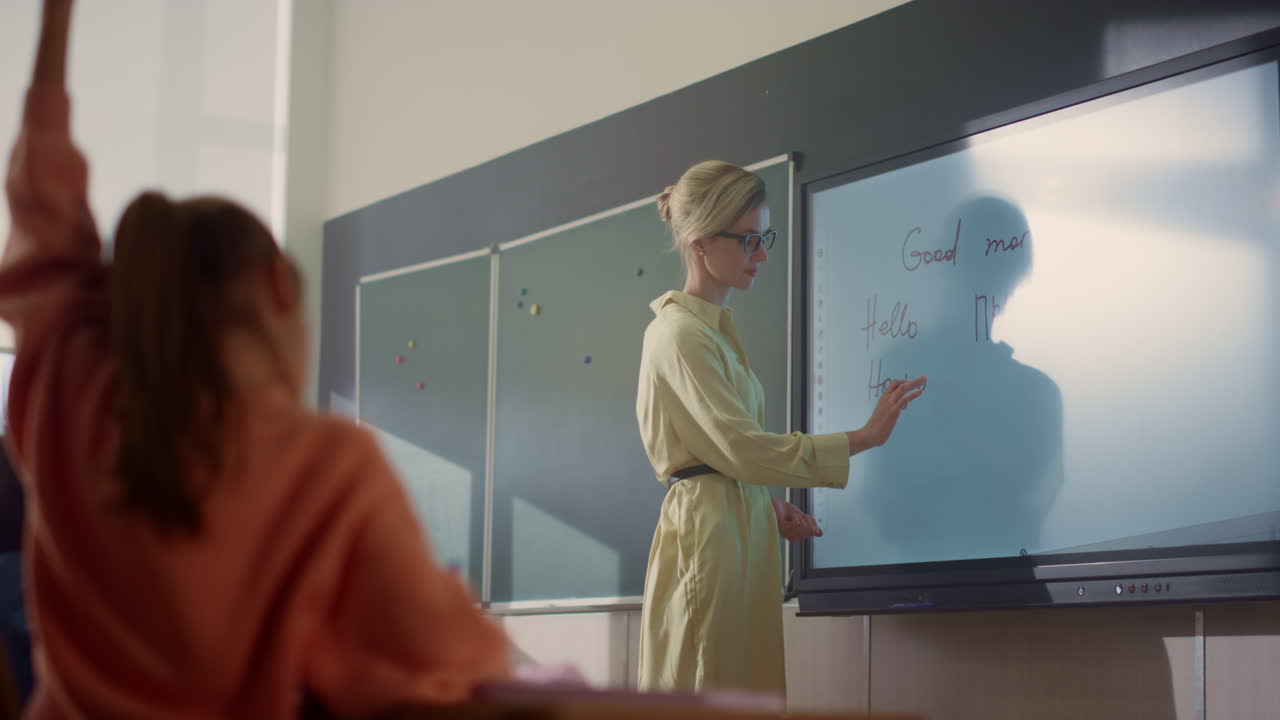 profesor escribiendo en una pizarra digital interactiva. estudiantes levantando las manos