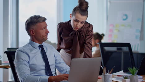 Hombre-Y-Mujer-Serios-Trabajando-Con-Computadora-Portátil-En-La-Oficina.-Pareja-De-Negocios-Discutiendo-Planes