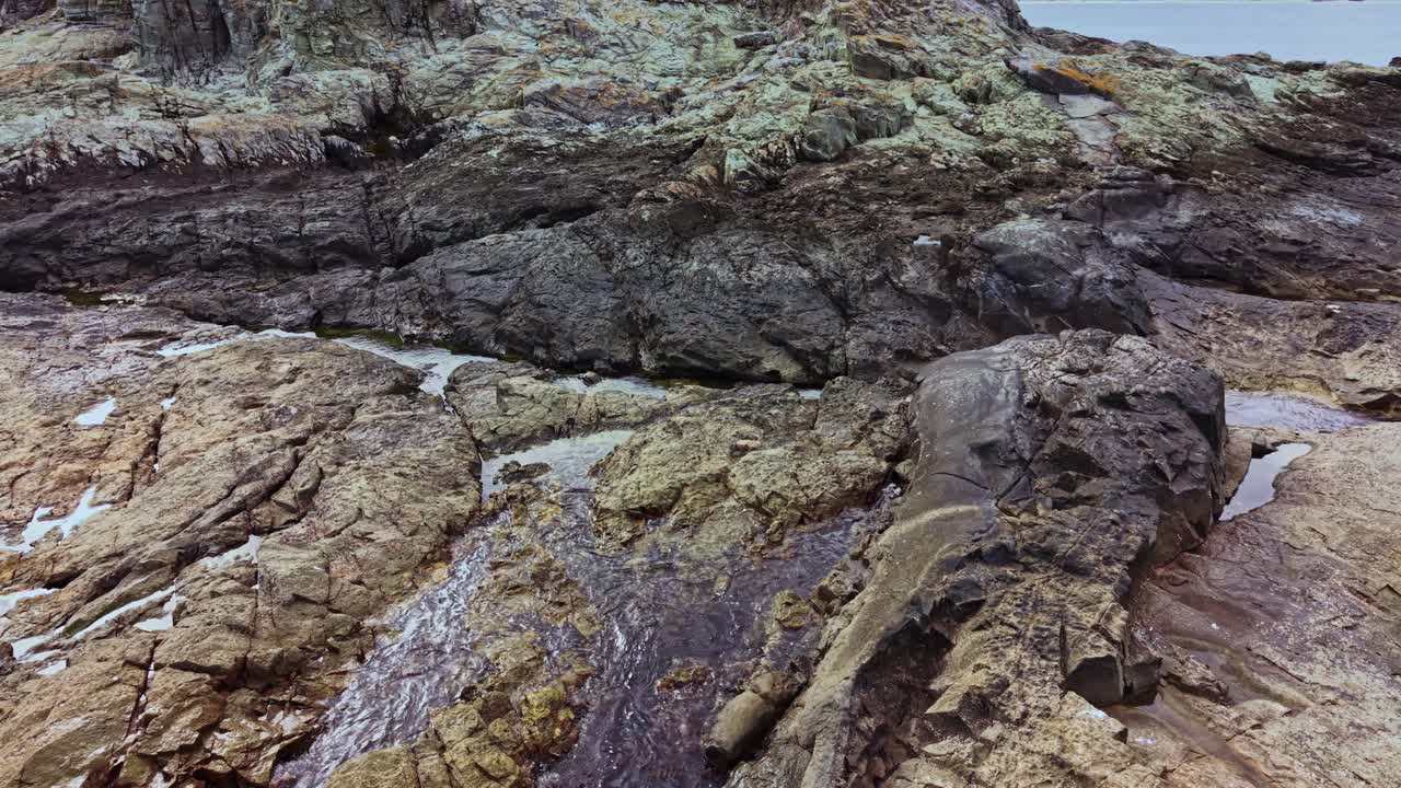 Scenic aerial view of rocky coastline with tidal pools at low tide