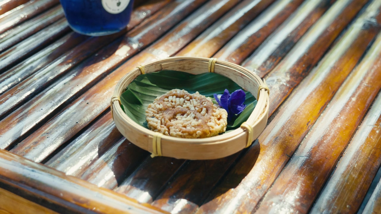 A Khao Taen, a traditional Thai crispy rice cracker, placed on a table, highlighting local Thai snacks and authentic cuisine.