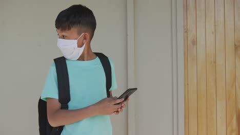 Boy-wearing-face-mask-using-smartphone