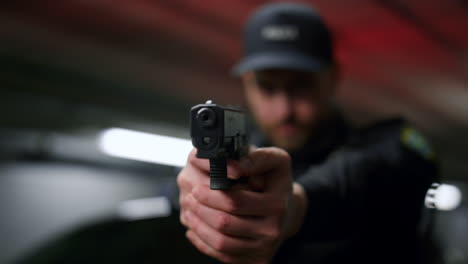 policeman aiming gun during operation. male cop with firearm posing at camera