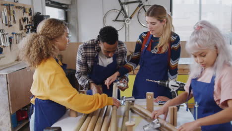 Multi-Cultural-Team-In-Workshop-Assembling-Hand-Built-Sustainable-Bamboo-Bicycle-Frame