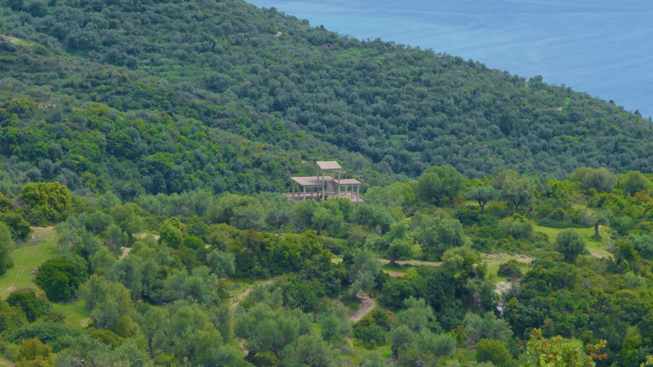 Fondamenta in cemento di una casa, paesaggio montano con foresta verde, ripresa con treppiede. Dettaglio di una struttura edilizia bianca incompiuta abbandonata nella natura boschiva alpina.