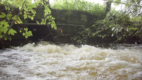 turbulent flow of rainwater out of drainage pipe, extreme weather flooding