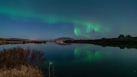 un video de lapso de tiempo en una noche tranquila con luces del norte reflejadas en un lago en islandia