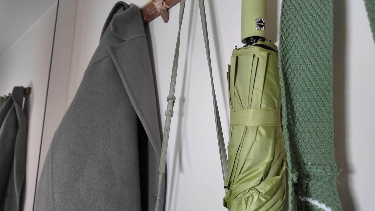 Coat, Umbrella, and Scarf Hanging on a Wall Hook