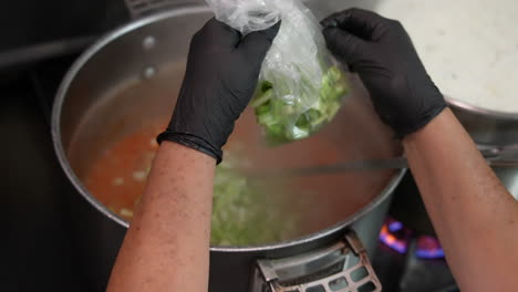 Adding-chopped-celery-to-a-large-pot-of-soup-in-an-industrial-or-restaurant-kitchen