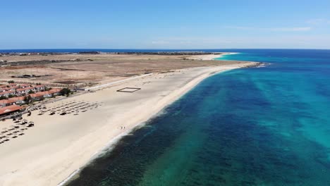 Luftaufnahme-Von-Bikini-Strandschirmen-Mit-Resort-Und-Schwimmbädern-Im-Hintergrund