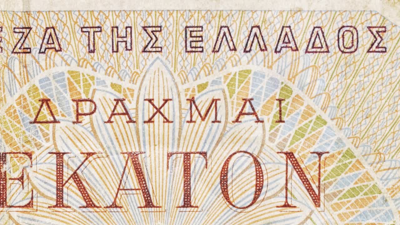 Close-up pan across Greek “Bank of Greece” lettering and guilloche on a drachma note