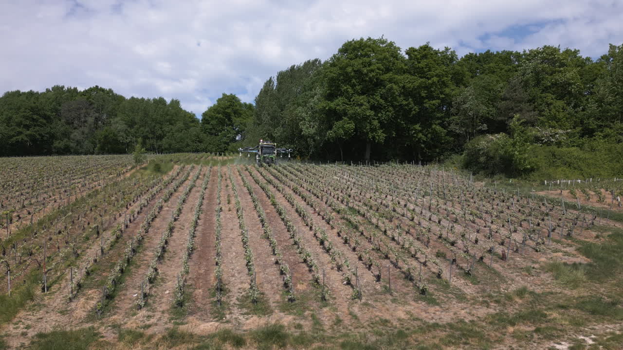 Farming equipment fertilizing grape fields in France, aerial view