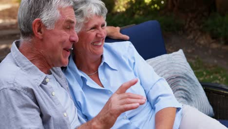 Happy-senior-couple-relaxing-on-bench-4k