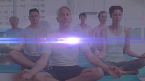 Animation-of-glowing-light-over-people-practicing-yoga