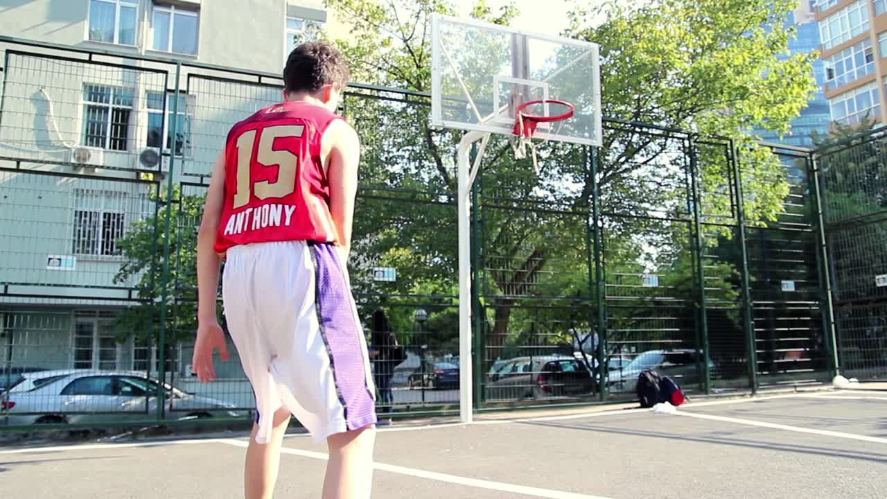 vista de atrás de un joven jugando al baloncesto 1