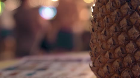 pineapple rind on table against blurred moving tourists