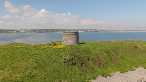 shenick island with offshore martello tower in county dublin, ireland. - aerial pullback shot