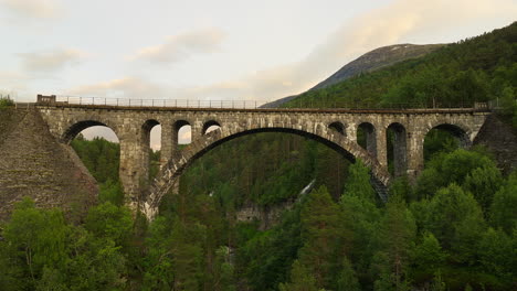 Drone-pullback-view-from-Kylling-Bridge-over-Rauma-river,-Verma,-Norway